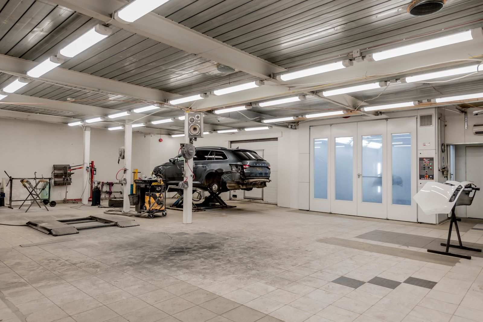 Oficina automotiva moderna, carro em elevador para reparo
